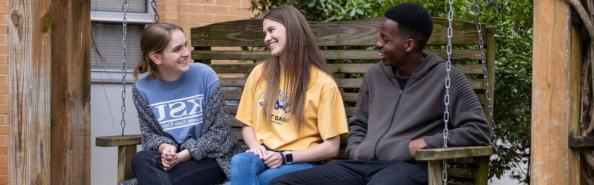 group of ksu students sitting on a bench talking